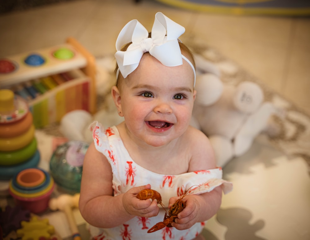 baby in white tank top smiling