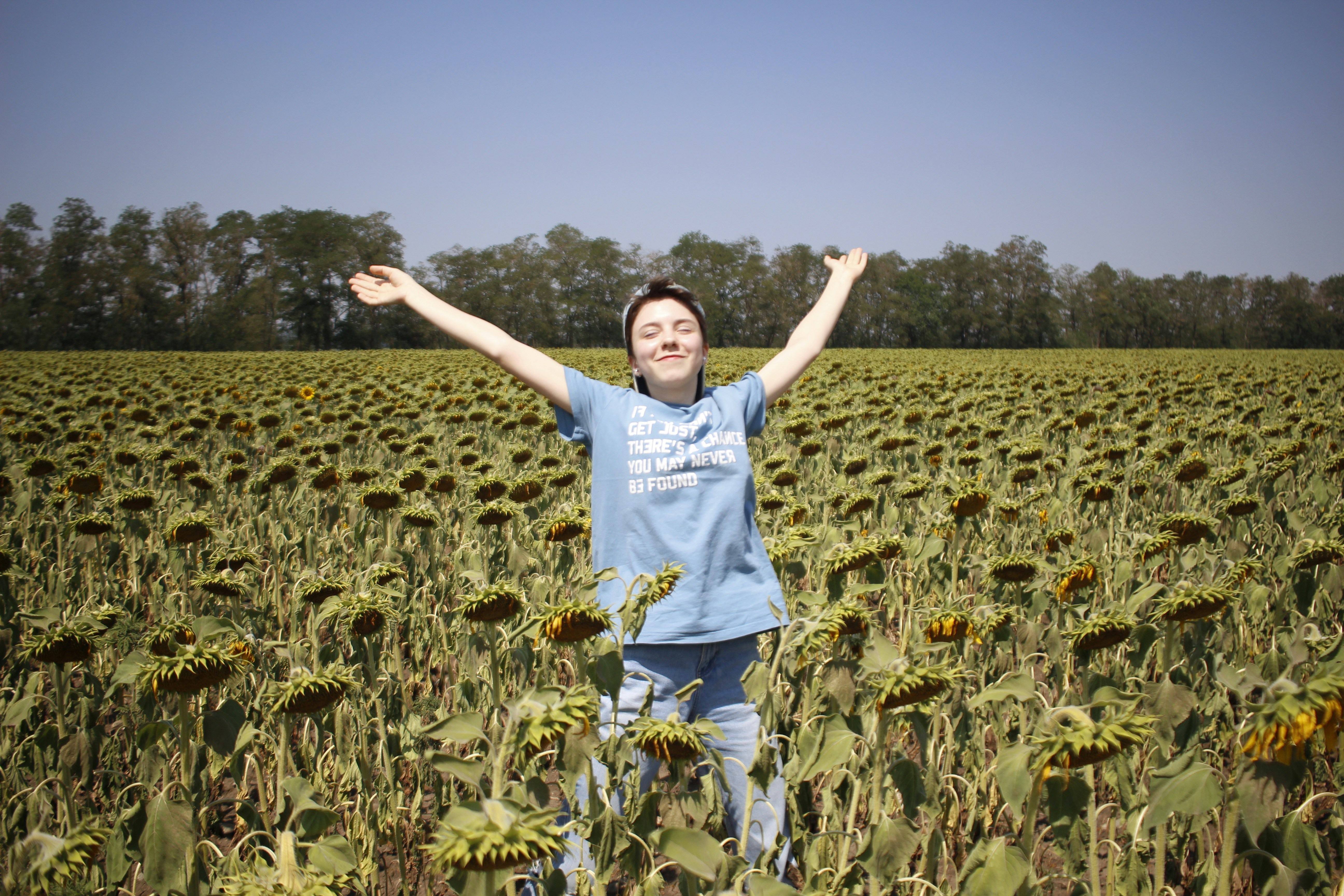 man in white t-shirt standing on green field during daytime