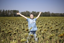 man in white t-shirt standing on green field during daytime