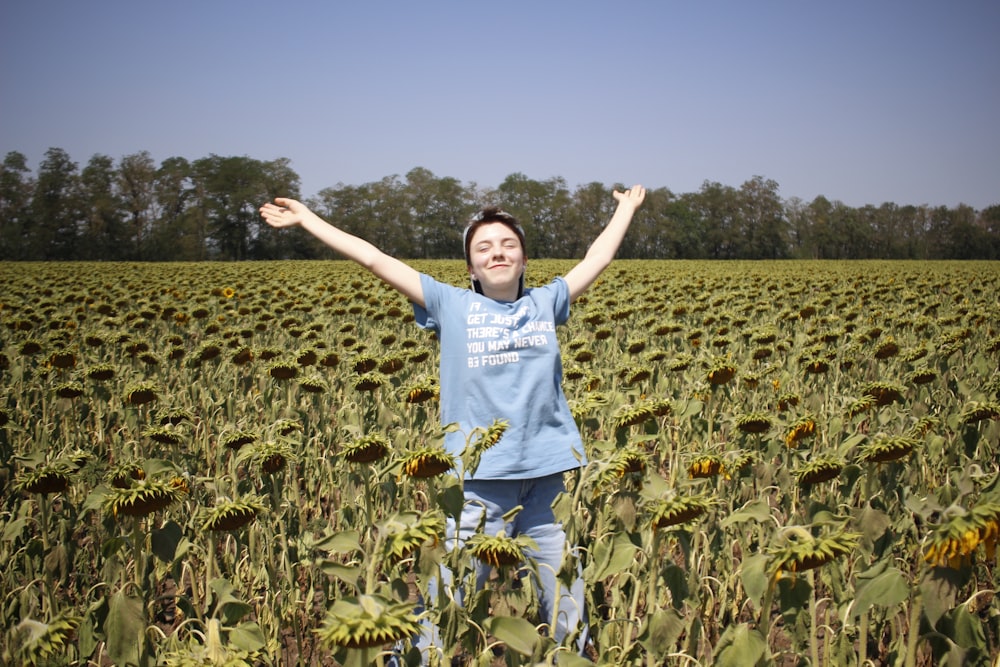 man in white t-shirt standing on green field during daytime
