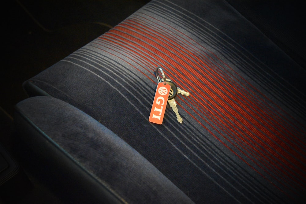 gold key on black and red textile