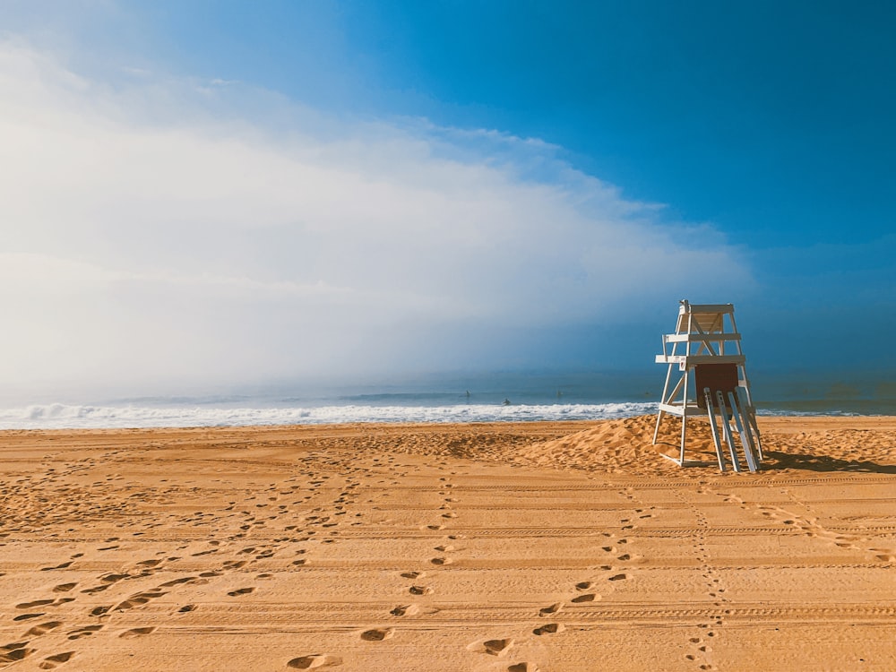 white wooden lifeguard house on beach shore during daytime