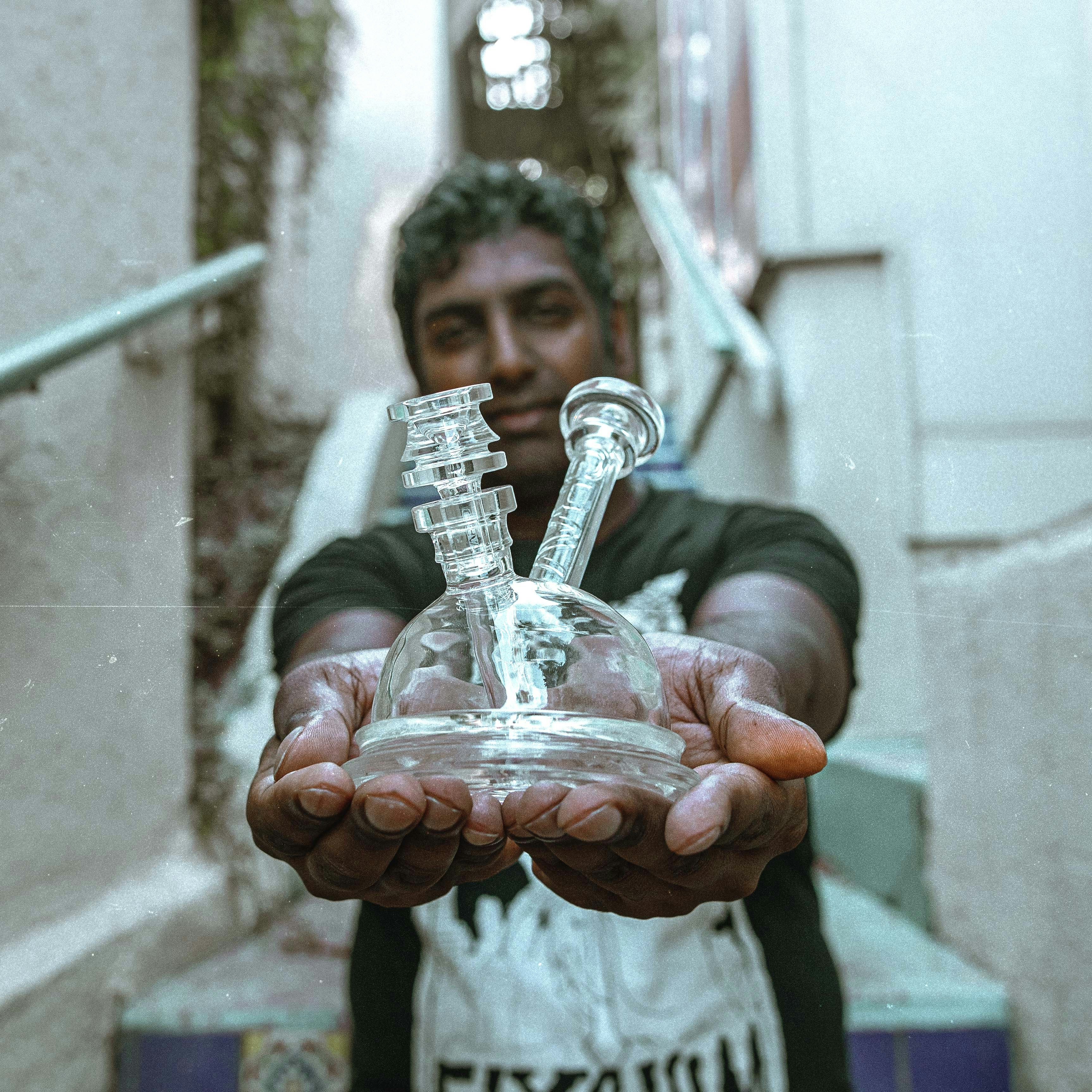 person holding clear glass bottle with red liquid