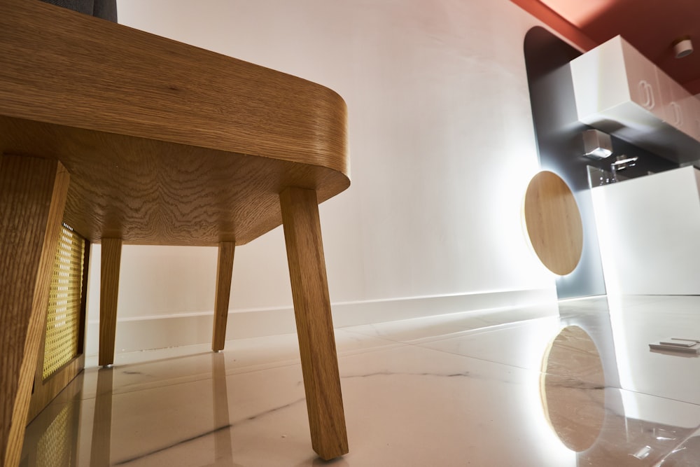 brown wooden table near white wall