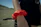 Close-up of hands tying a colorful, handmade scrunchie around a ponytail outdoors.