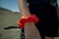 A close-up of a hand holding a colorful crocheted scrunchie against a sunny window background.