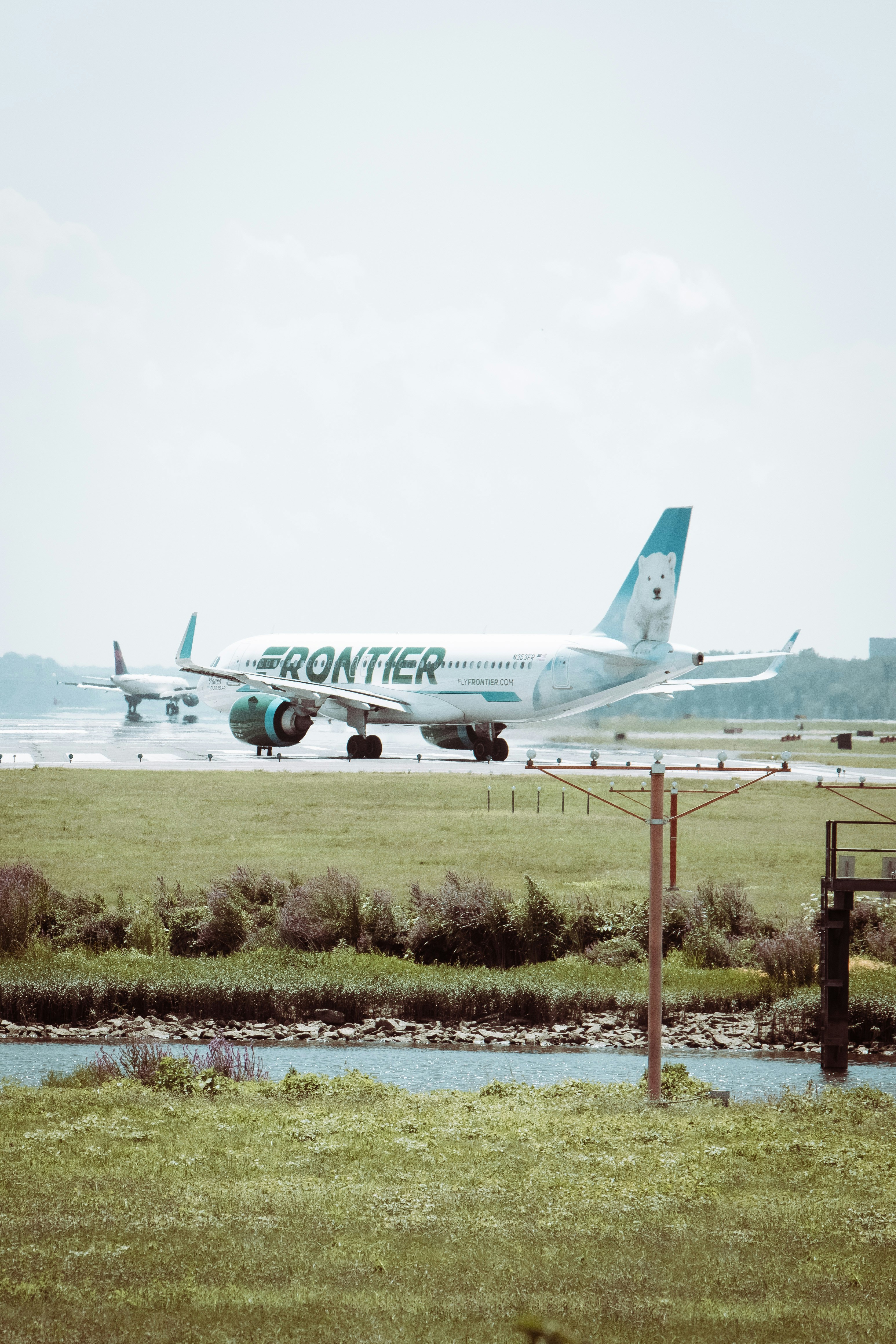 white passenger plane on green grass field during daytime. frontier airlines gowild