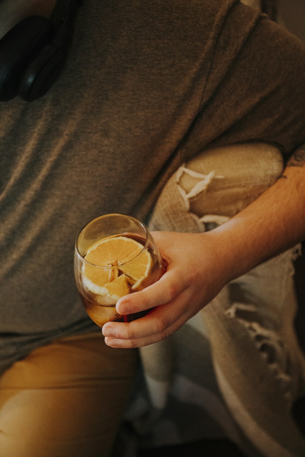 갈색 액체가 든 투명한 음료수 잔을 들고 있는 사람