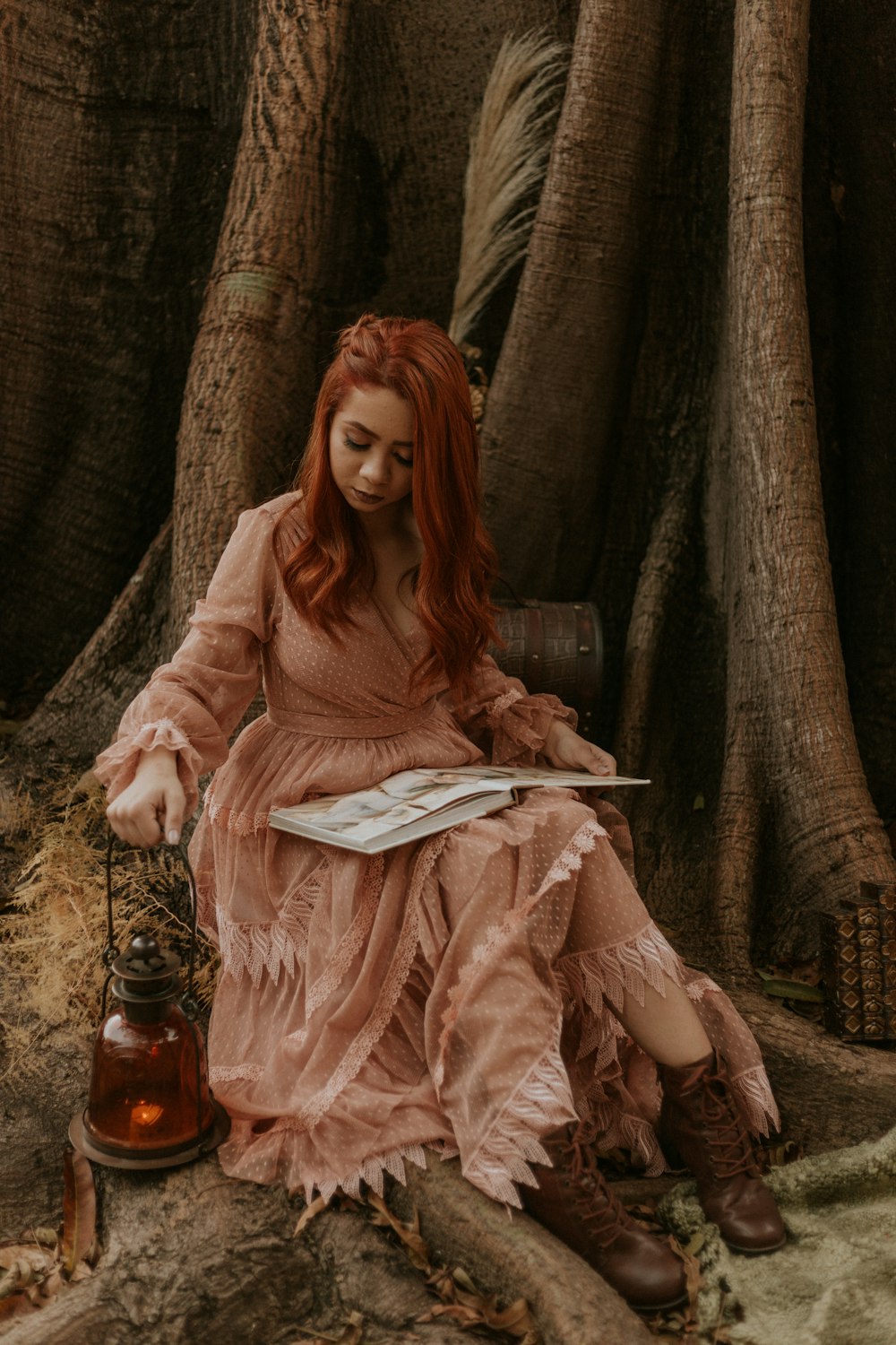 Femme en chemise rose à manches longues assise sur une chaise en bois marron livre de lecture