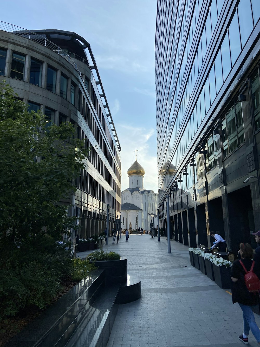 personnes marchant sur le trottoir près d’un bâtiment pendant la journée