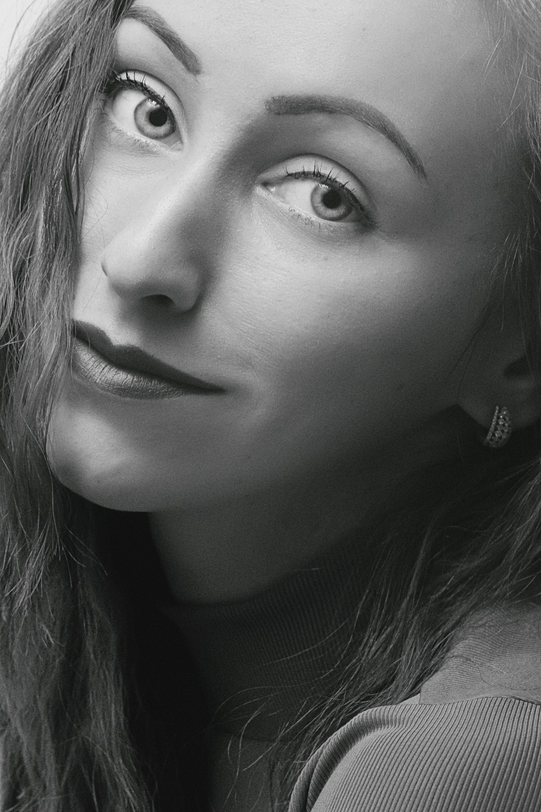 grayscale photo of woman with silver stud earrings
