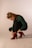 woman in green long sleeve shirt and red boots sitting on white floor