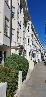 A neat row of well-maintained UK homes under a bright blue sky, symbolizing Harbornest's management.