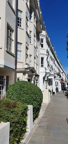 A neat row of well-maintained UK homes under a bright blue sky, symbolizing Harbornest's management.