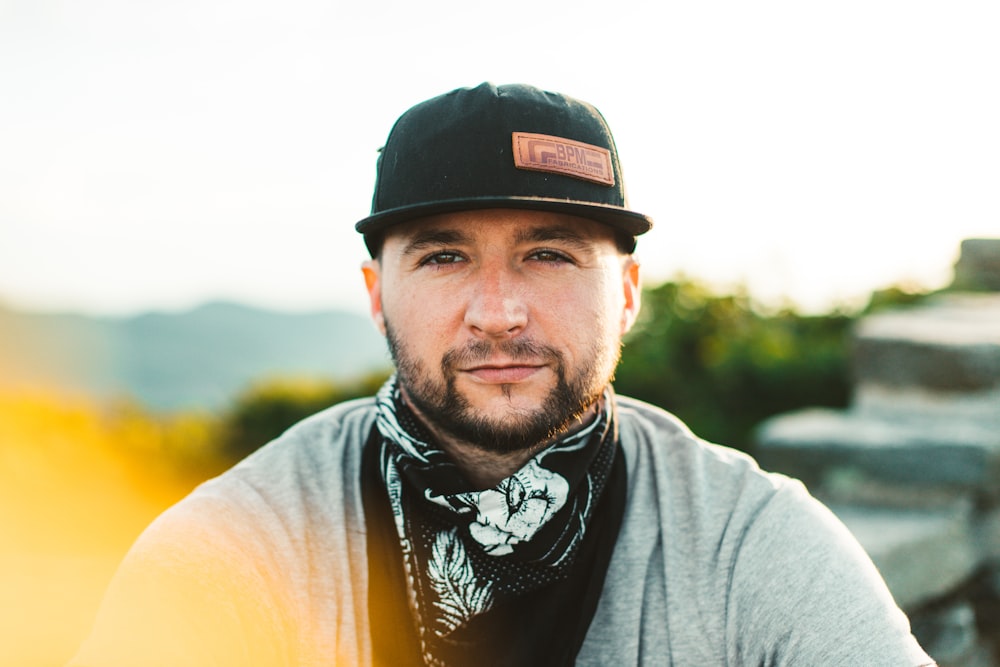 man in yellow crew neck shirt wearing black cap