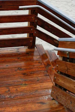 A wooden deck being pressure washed, revealing fresh wood grain beneath.