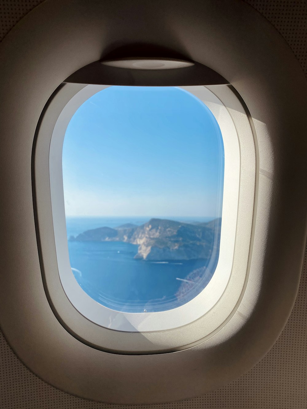 airplane window view of clouds and blue sky during daytime