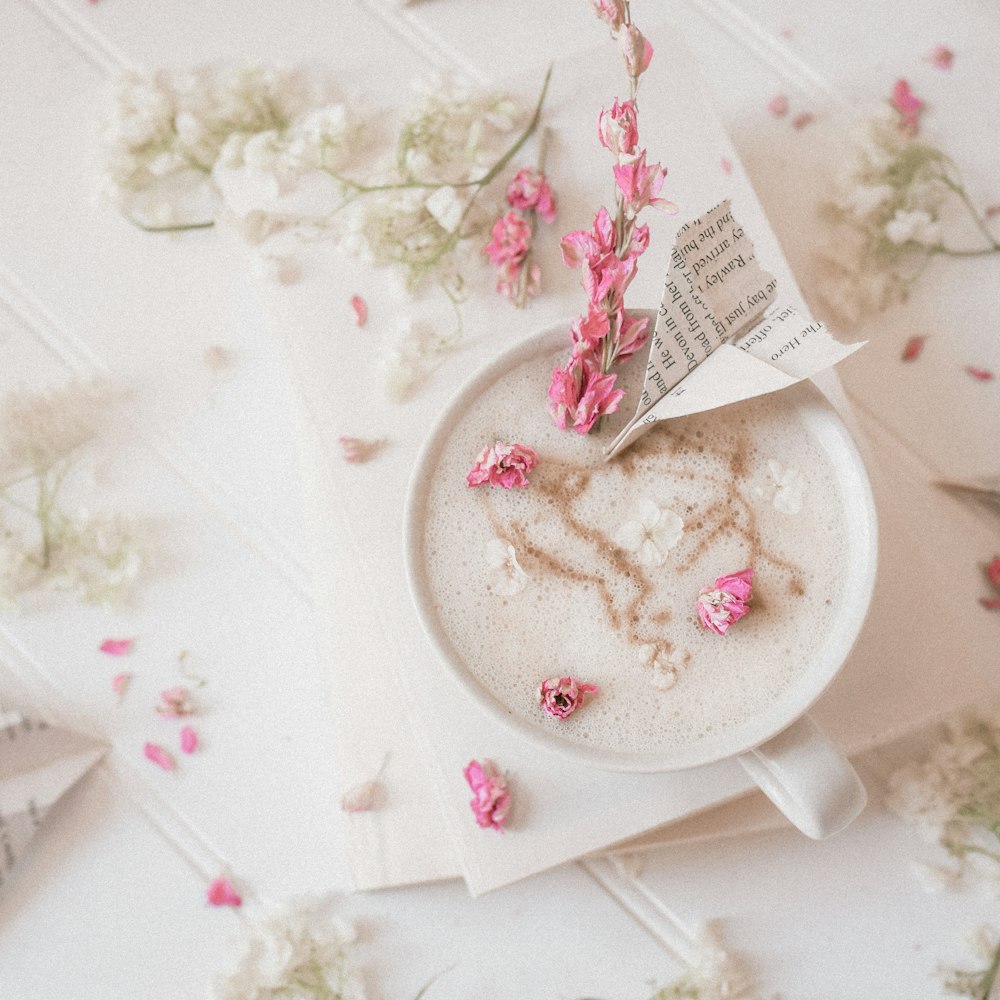 una tazza di caffè con fiori rosa su un tavolo