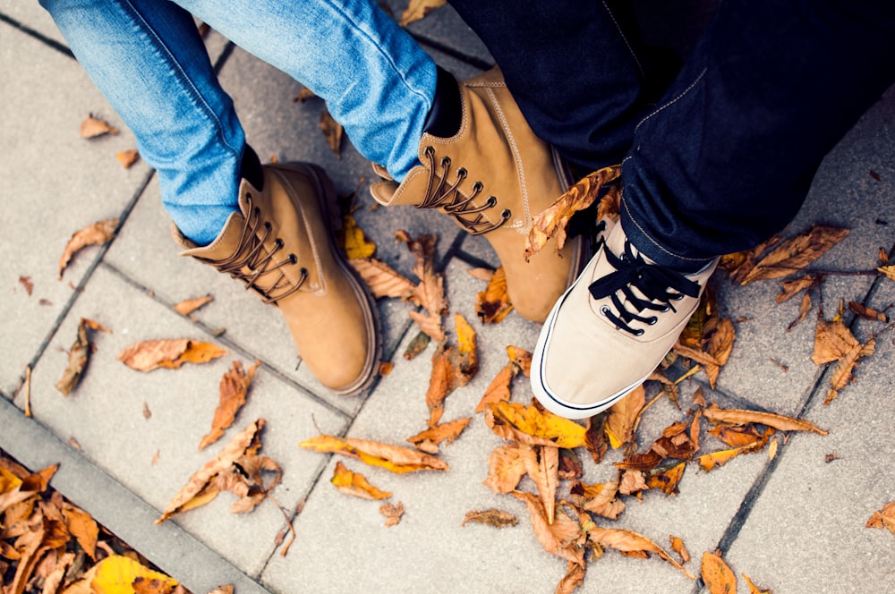 person in blue denim jeans and brown and white sneakers