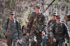 men in camouflage uniform standing on field during daytime