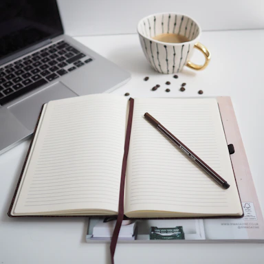 white notebook beside silver macbook pro