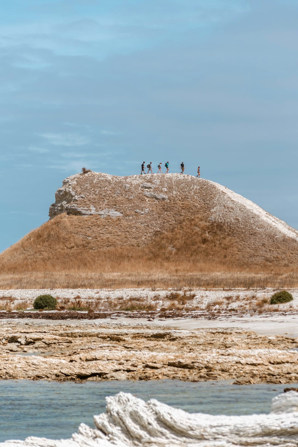 personnes debout sur une formation rocheuse brune pendant la journée