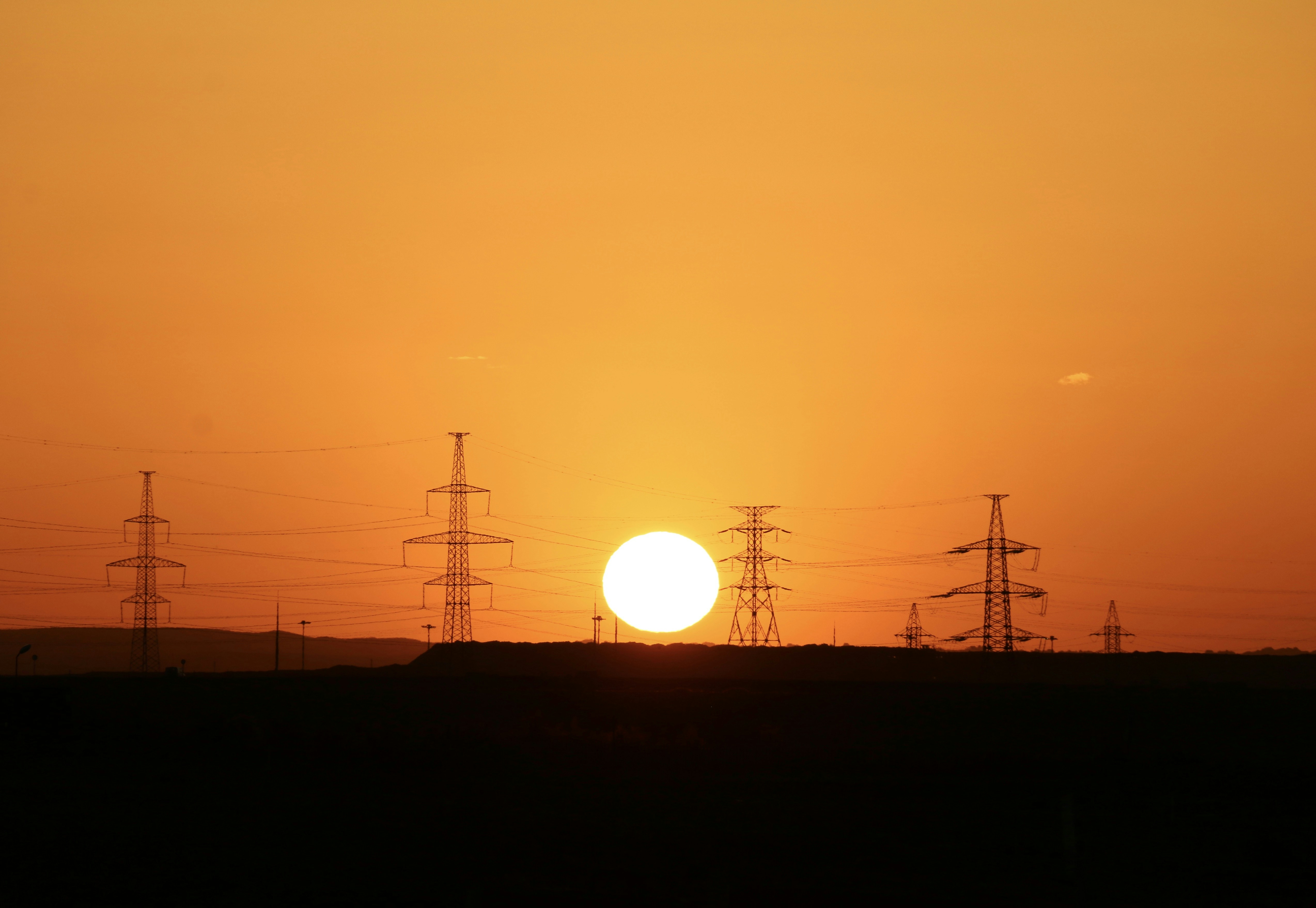 silhouette of electric posts during sunset