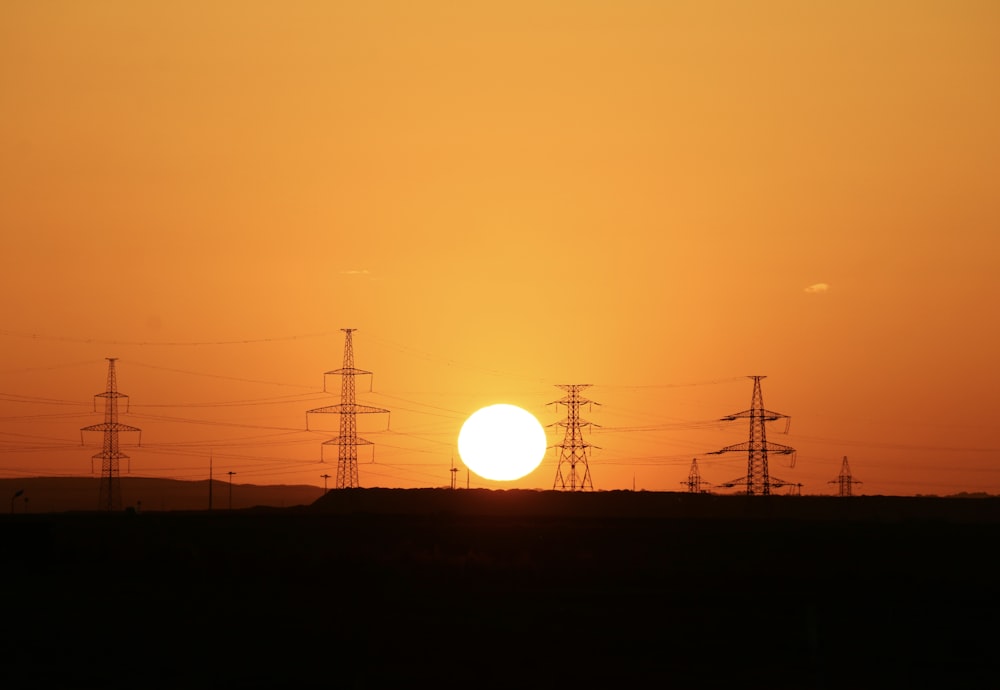 silhouette of electric posts during sunset