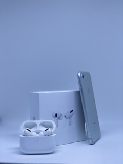 A sleek modern smartphone and wireless earbuds on a clean white surface.