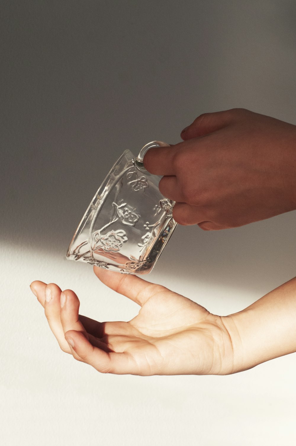 person holding clear glass mug