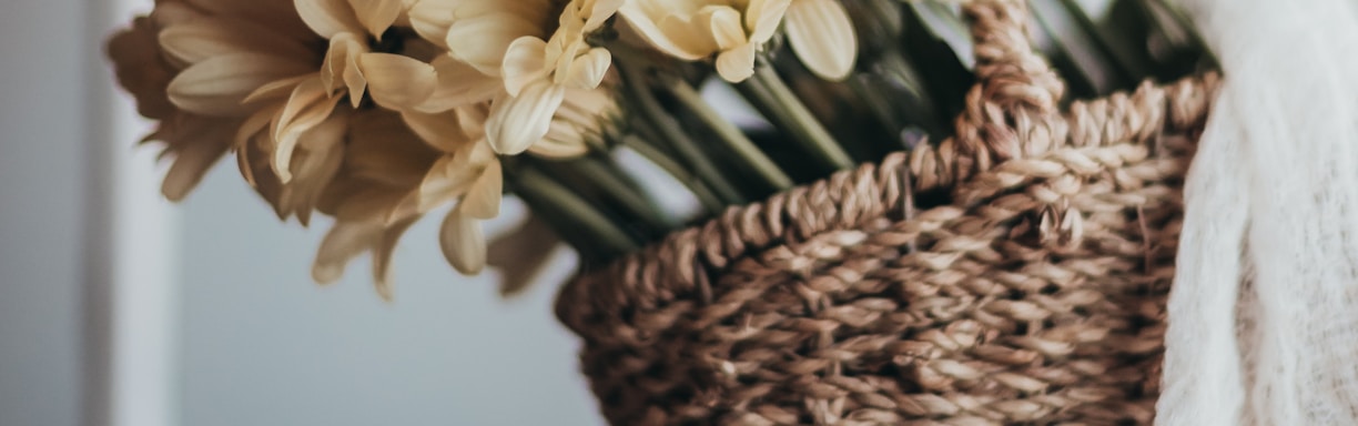 yellow flowers in brown woven basket