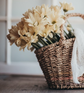 yellow flowers in brown woven basket