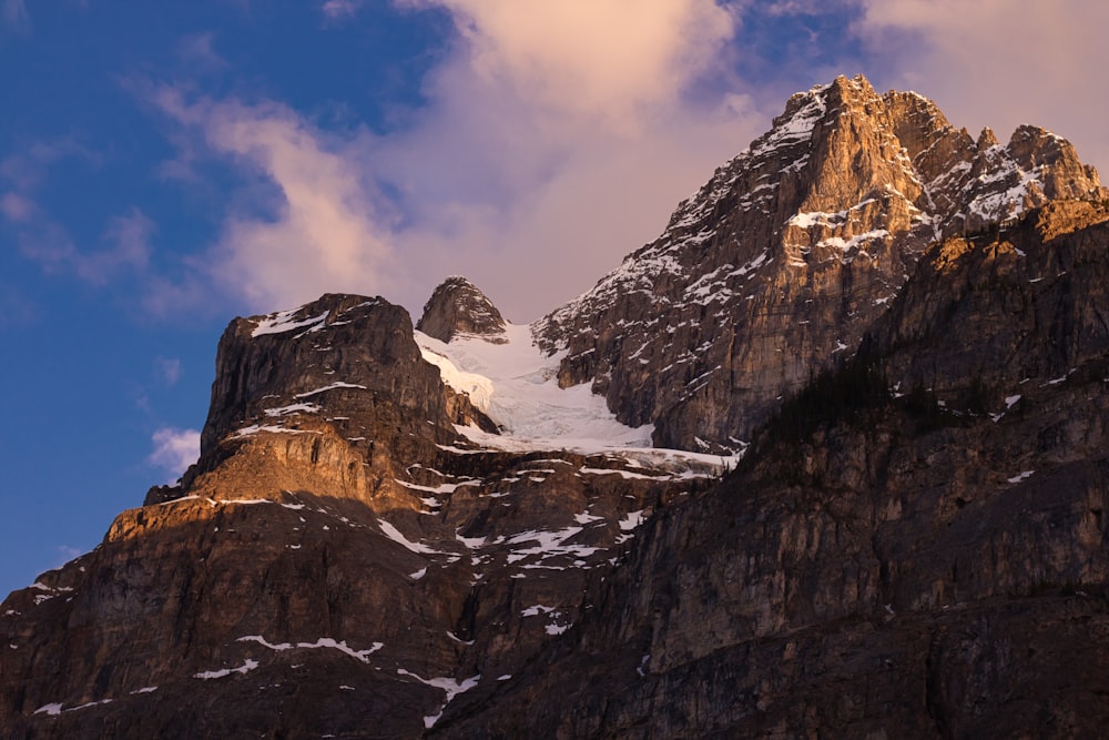 snow covered mountain under cloudy sky during daytime