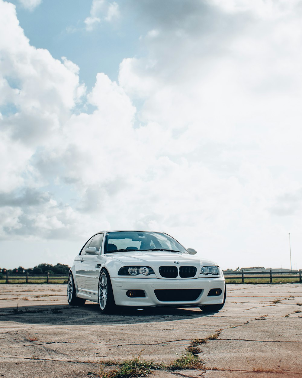 white bmw m 3 coupe on brown field under white clouds during daytime