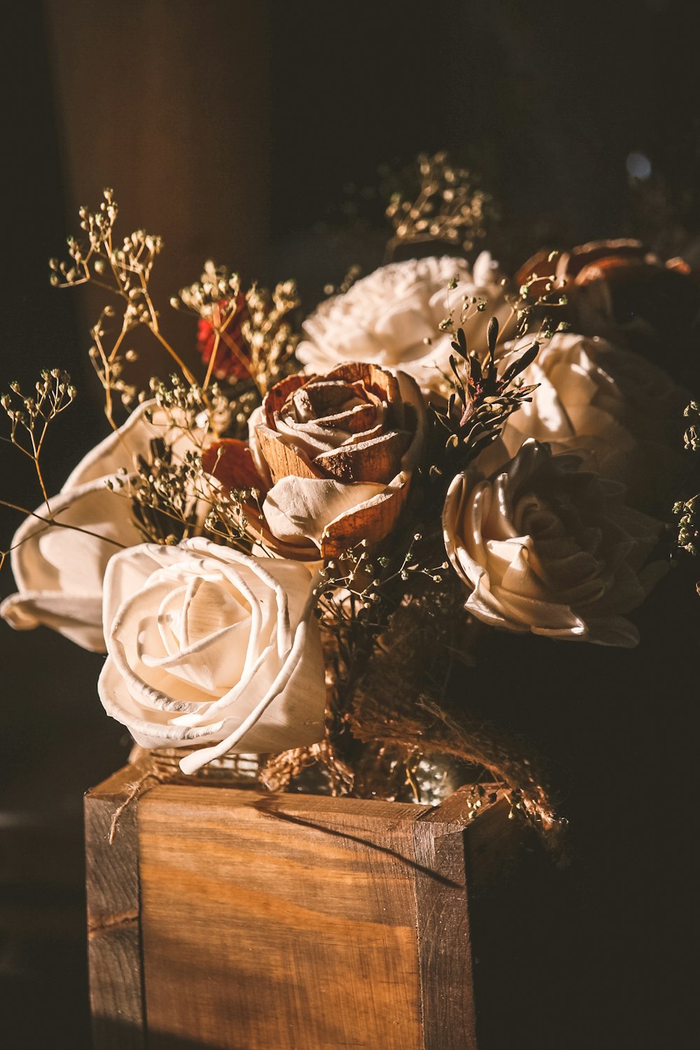 茶色の木製のテーブルに白いバラの花束