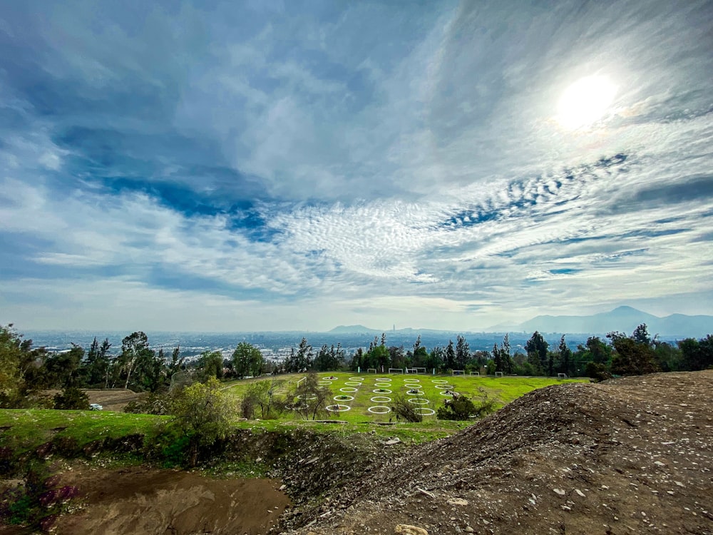 green grass field under blue sky and white clouds during daytime