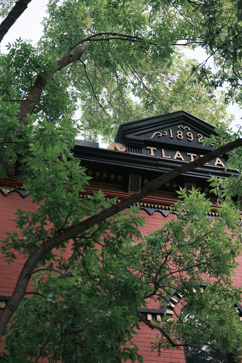 brown wooden house near green trees during daytime