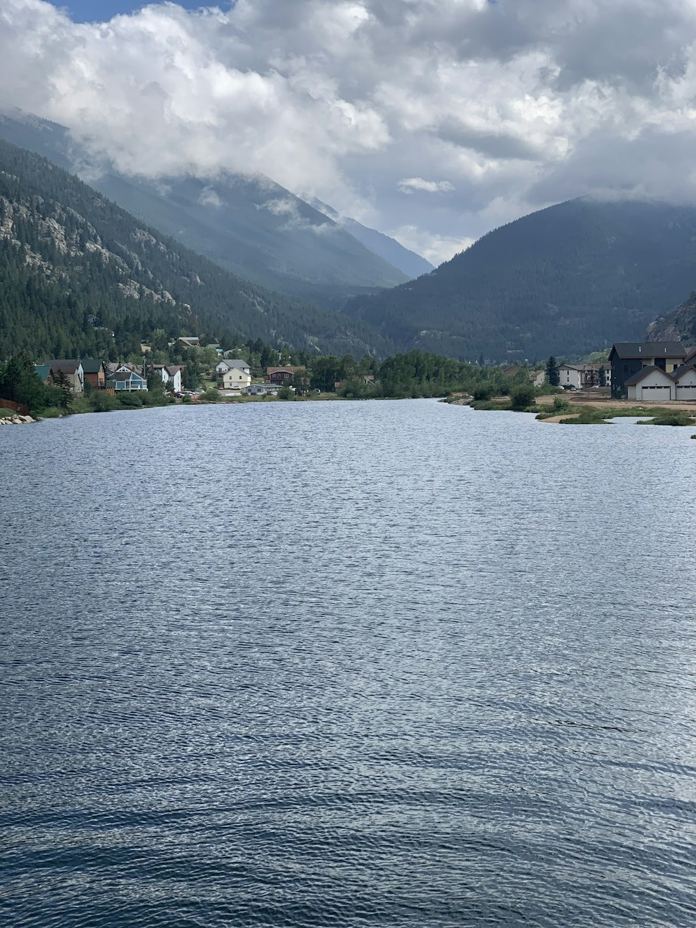 body of water near green mountain during daytime