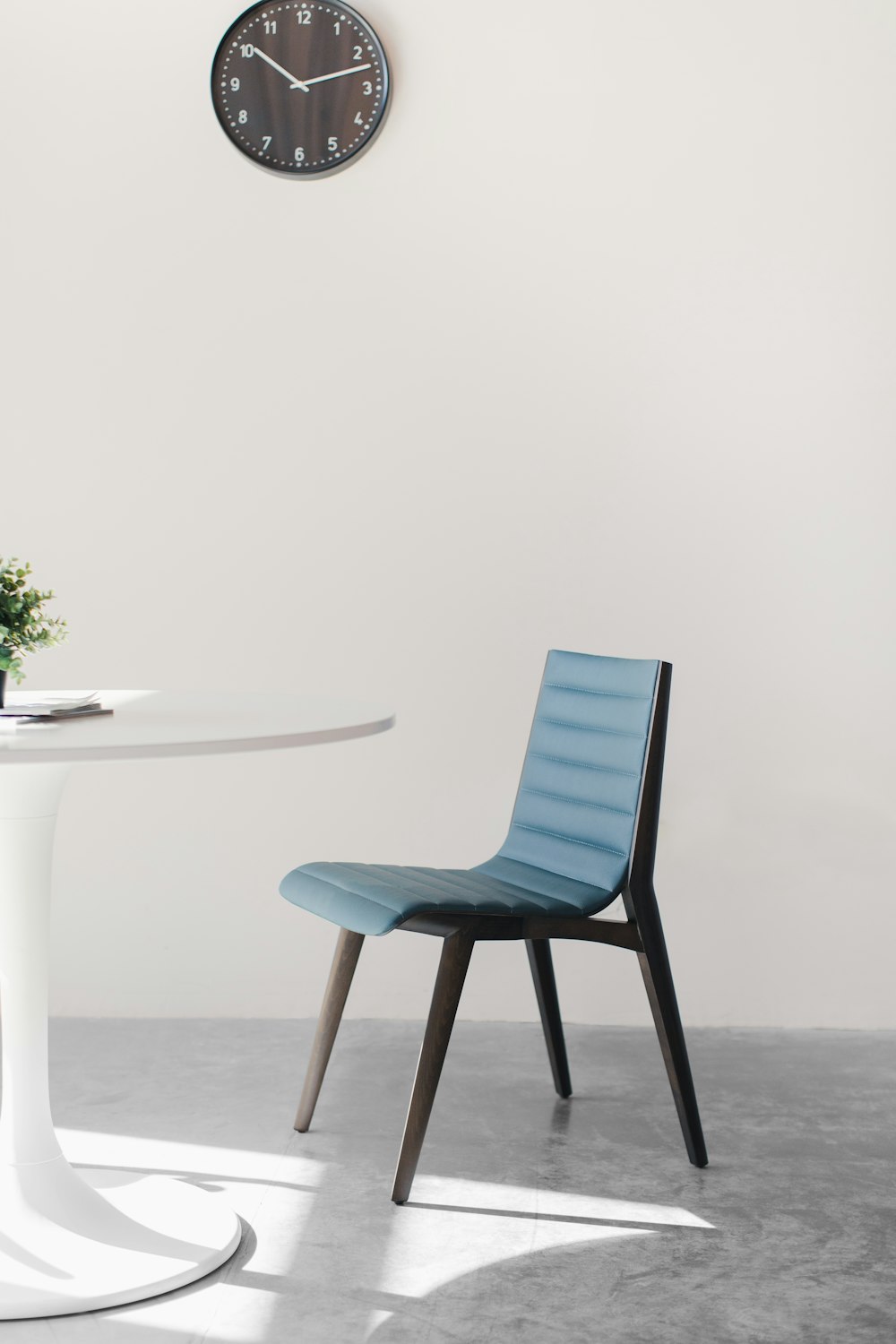 白いテーブルの横の青い木製の椅子
