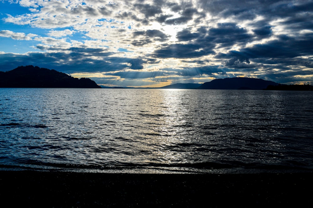 body of water under cloudy sky during daytime