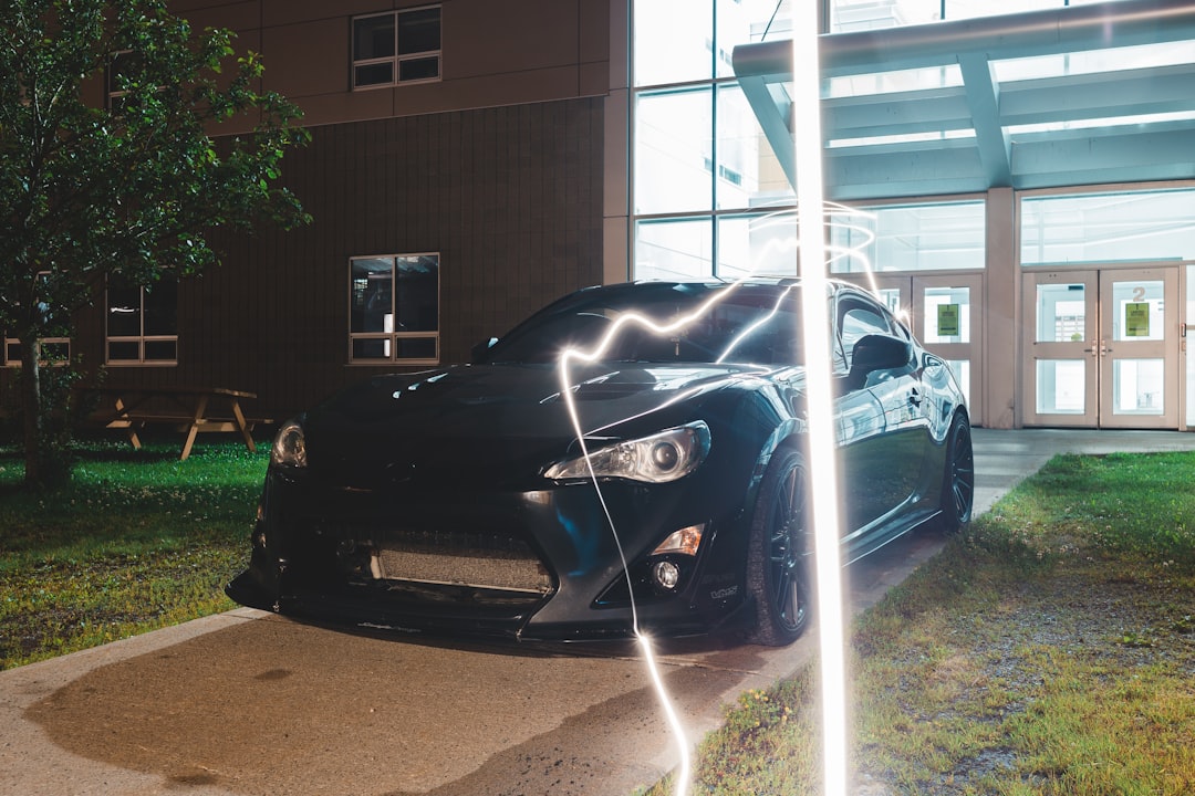 black porsche 911 parked near white building