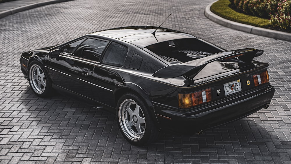 a black sports car parked on a brick road