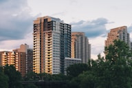 a group of tall buildings sitting next to a river