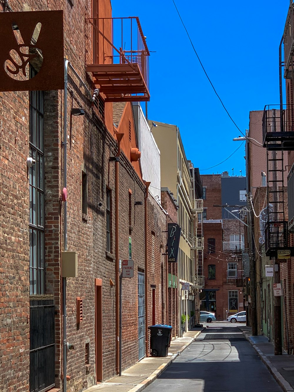 cars parked beside brown concrete building during daytime