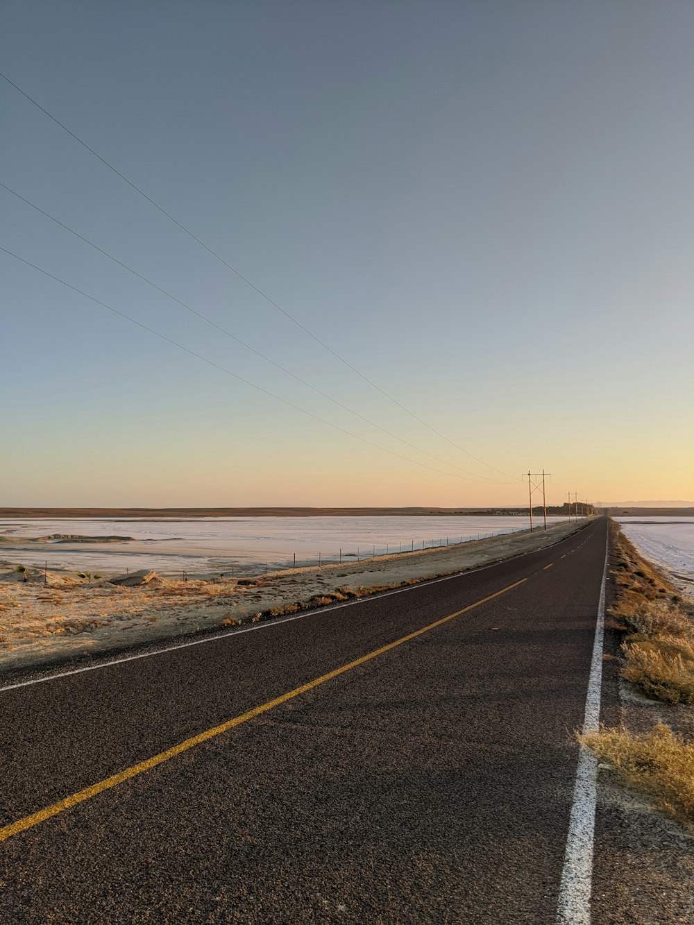 gray concrete road near sea during daytime