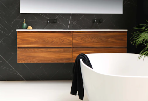 white ceramic bathtub near brown wooden cabinet