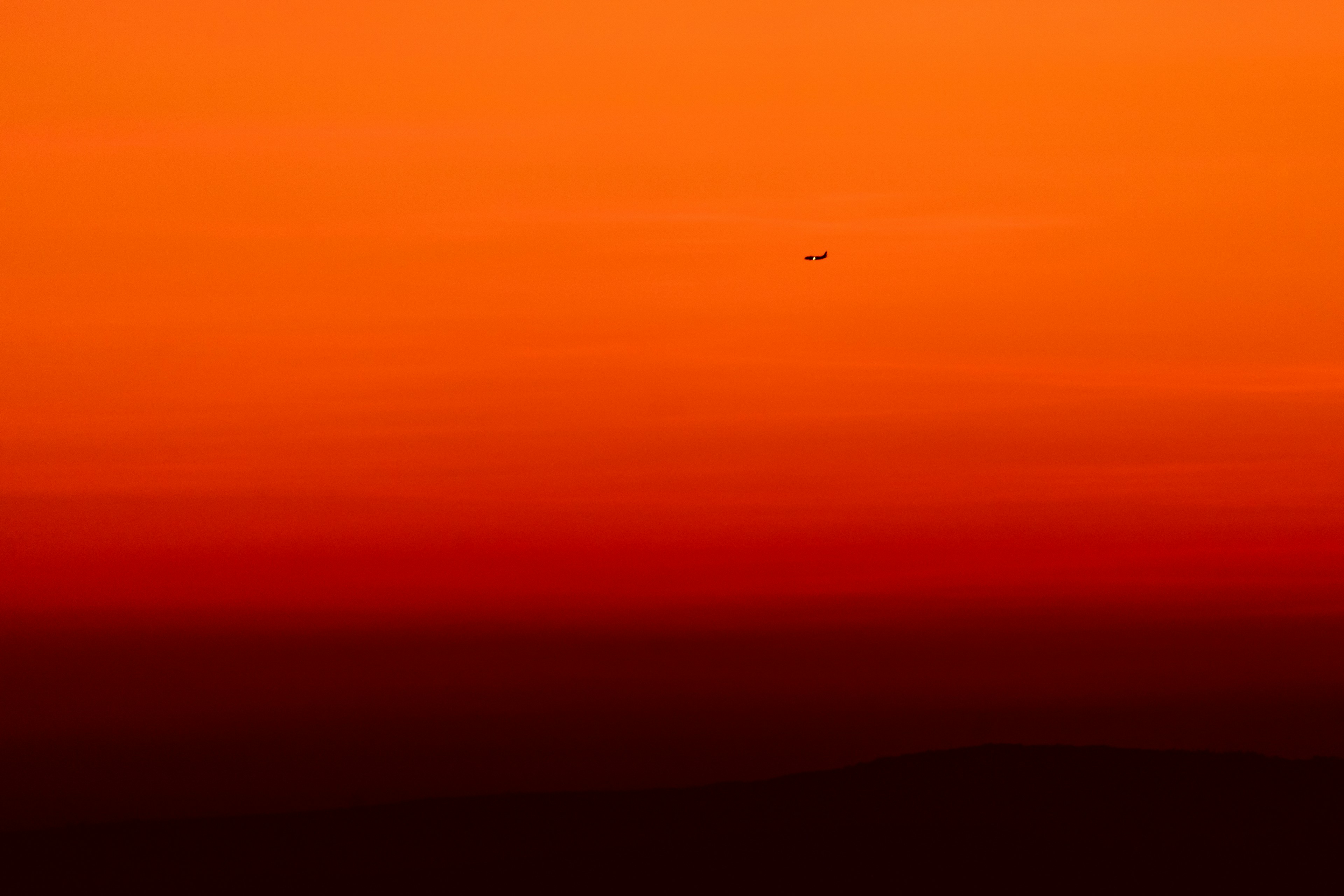 airplane flying over the sky during sunset