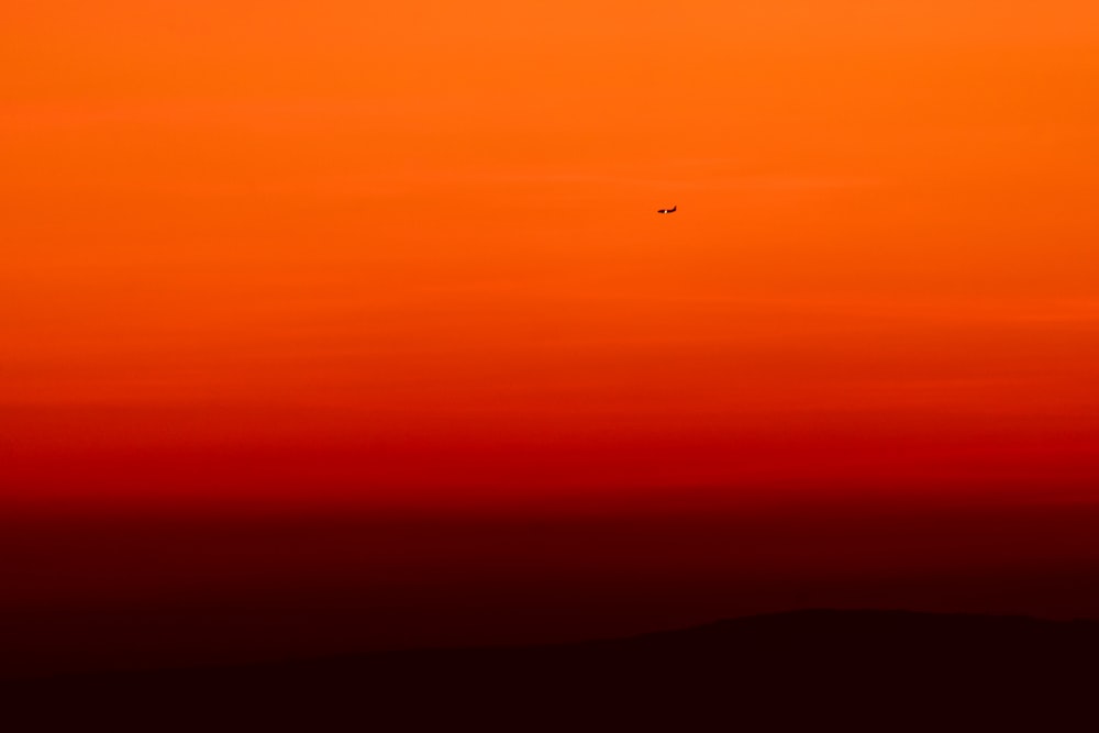 aeroplano che vola sopra il cielo durante il tramonto