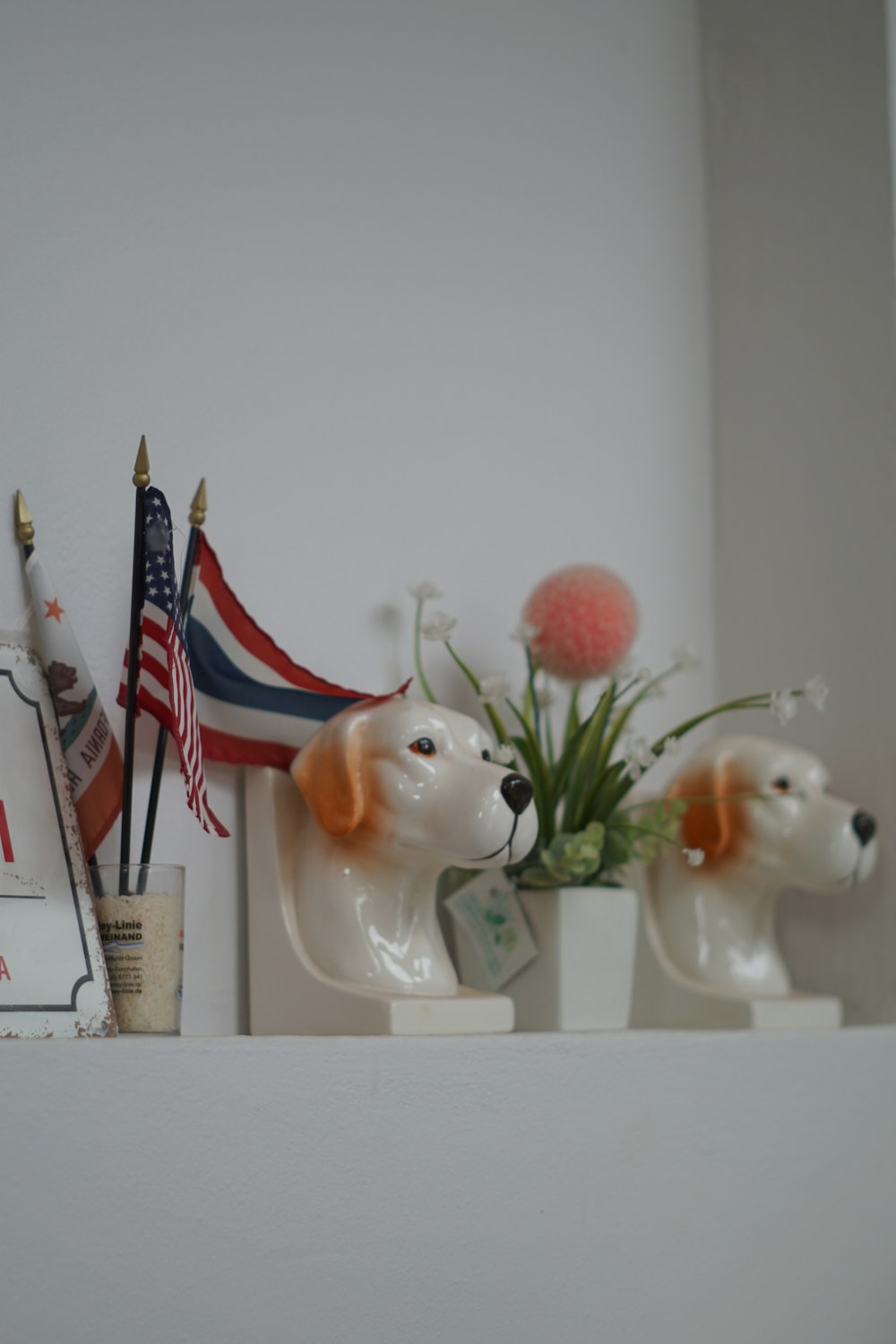 white ceramic cat figurine on white wooden shelf