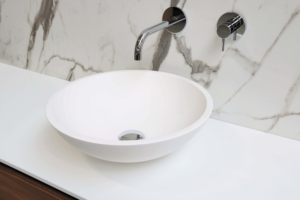 stainless steel faucet on white ceramic sink